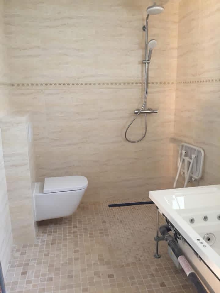 Salle d'eau PMR carrelée en travertin et mosaïque